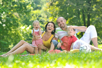 Fototapeta premium happy young couple with their children have fun at park