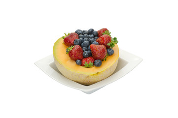Fruit desert of berries and cantaloupe in white bowl