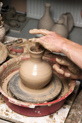 hands of a potter, creating an earthen jar on the circle