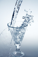 Pouring mineral water stream into a glass