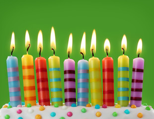 Ten colorful candles on green background