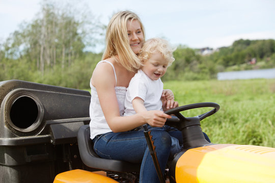 Mother And Child Mowing Grass