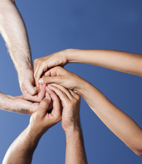 Spirale aus drei H&auml;nden vor blauem Himmel