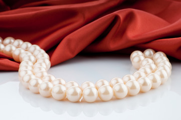 Pearls necklace on satin background