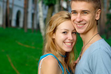Fototapeta premium Happy young couple at the park with a building at the background