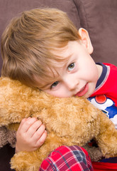 Cute kid cuddling teddy bear
