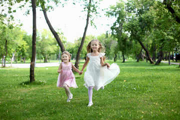 Naklejka na ściany i meble Two little sisters in the summer park
