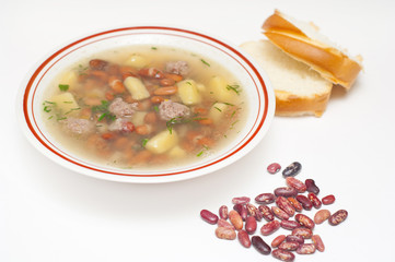 Pinto beans soup and bread isolated on white