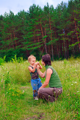 Fototapeta premium Mother and young son in a green forest