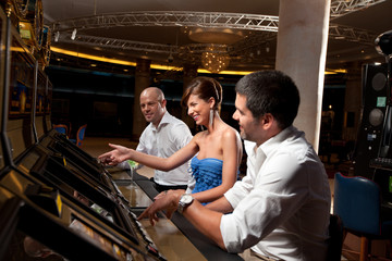 excited friends playing at gaming machines