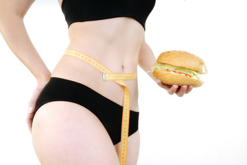 woman measuring waist measuring tape and hamburger