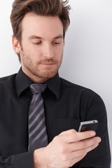 Portrait of young businessman with mobile