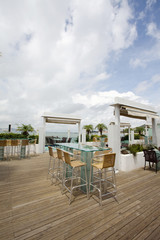 Beach cafe with  tables and chairs placed at the sea waterfront