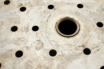 The metal surface with circular holes.