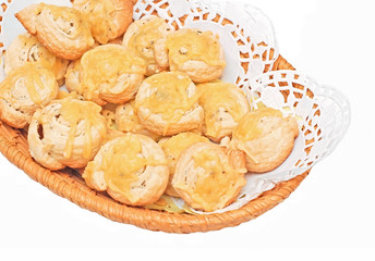 Small cheese rolled brioche bun in wicker basket on white