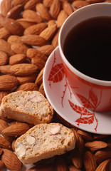 Coffee with biscotti on almond background