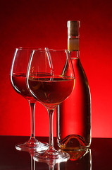wine bottle and glasses on red background