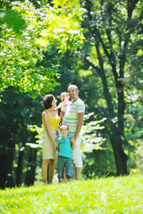 Fototapeta premium happy young couple with their children have fun at park