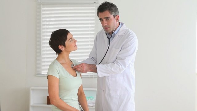 Doctor examining a cute woman