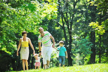 Obraz premium happy young couple with their children have fun at park