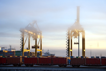 Harbor cranes in foggy morning