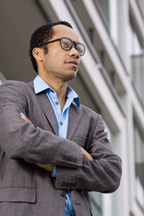 Business man with crossed arms in front of office buildung