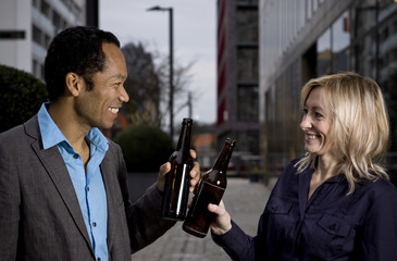 Business couple in smart casual drinking after work beer