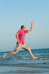 Fototapeta premium Young man jumping in the ocean