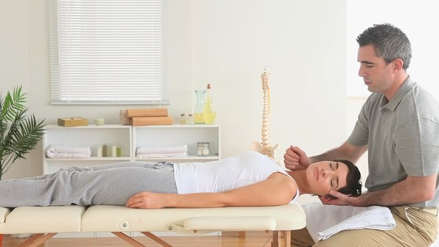 Chiropractor massaging a woman's neck