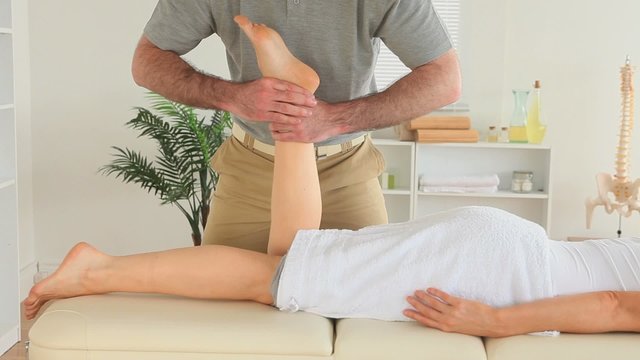Chiropractor massaging a woman's foot
