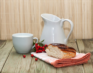 pitcher of milk and a piece of cake on a wooden table