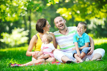 happy young couple with their children have fun at park