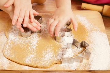 little girls cutting  gingerbread christmas cookies, hands only