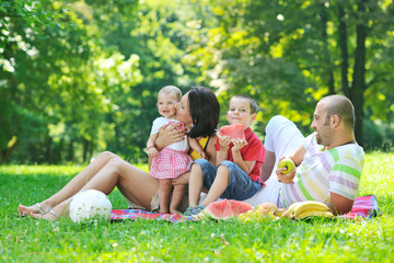 Fototapeta premium happy young couple with their children have fun at park