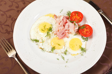 fried eggs with bacon and vegetables
