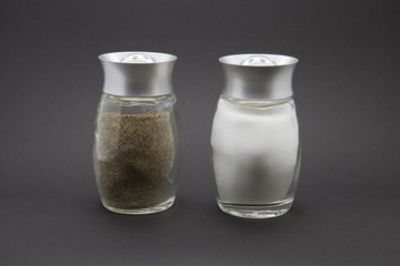 Condiments. Salt and Pepper on a black background