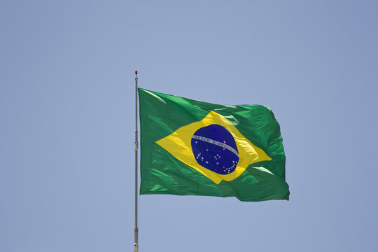 Brazilian flag in the wind over the blue sky