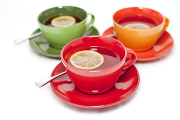 Colored tea cups with tea and lemon