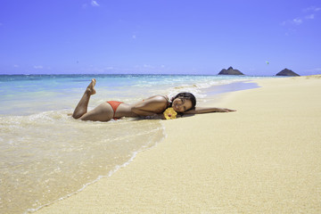Fototapeta na wymiar Dziewczynka piękne leżącego na piasku na brzegu oceanu