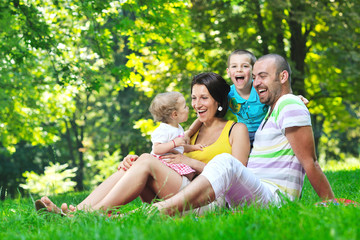 Fototapeta premium happy young couple with their children have fun at park
