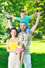 happy young couple with their children have fun at park