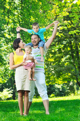 Fototapeta premium happy young couple with their children have fun at park