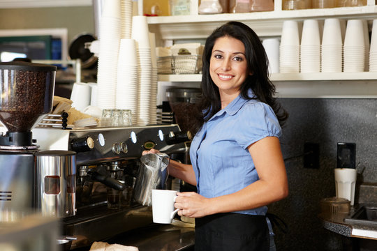 Woman working in coffee shop - Powered by Adobe