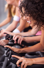 Attractive females on bicycles in a gym