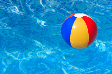 A colorful beach ball floating in a swimming pool