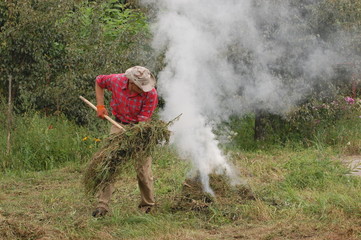 Man burn out dry grass in the garden.Ukraine