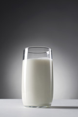 glass of milk on grey background