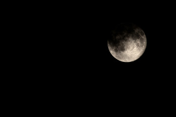 Dark Moody Cloud Covered Full Moon Waning by One Day.