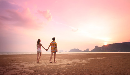 Young couple walking on a sandy coast