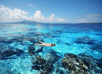 Young woman swimming in a clear tropical sea